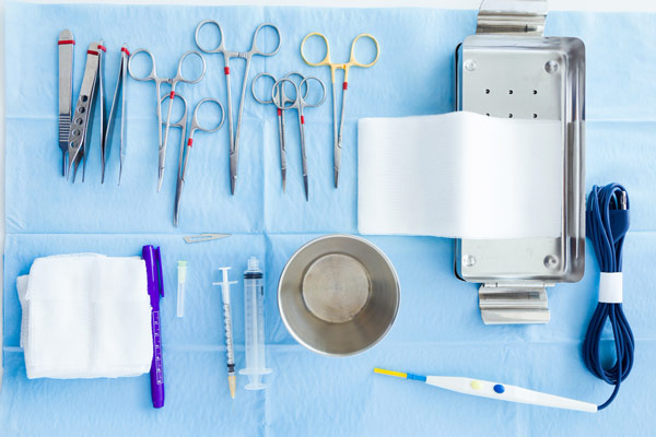 Surgical kit with various instruments on a table.